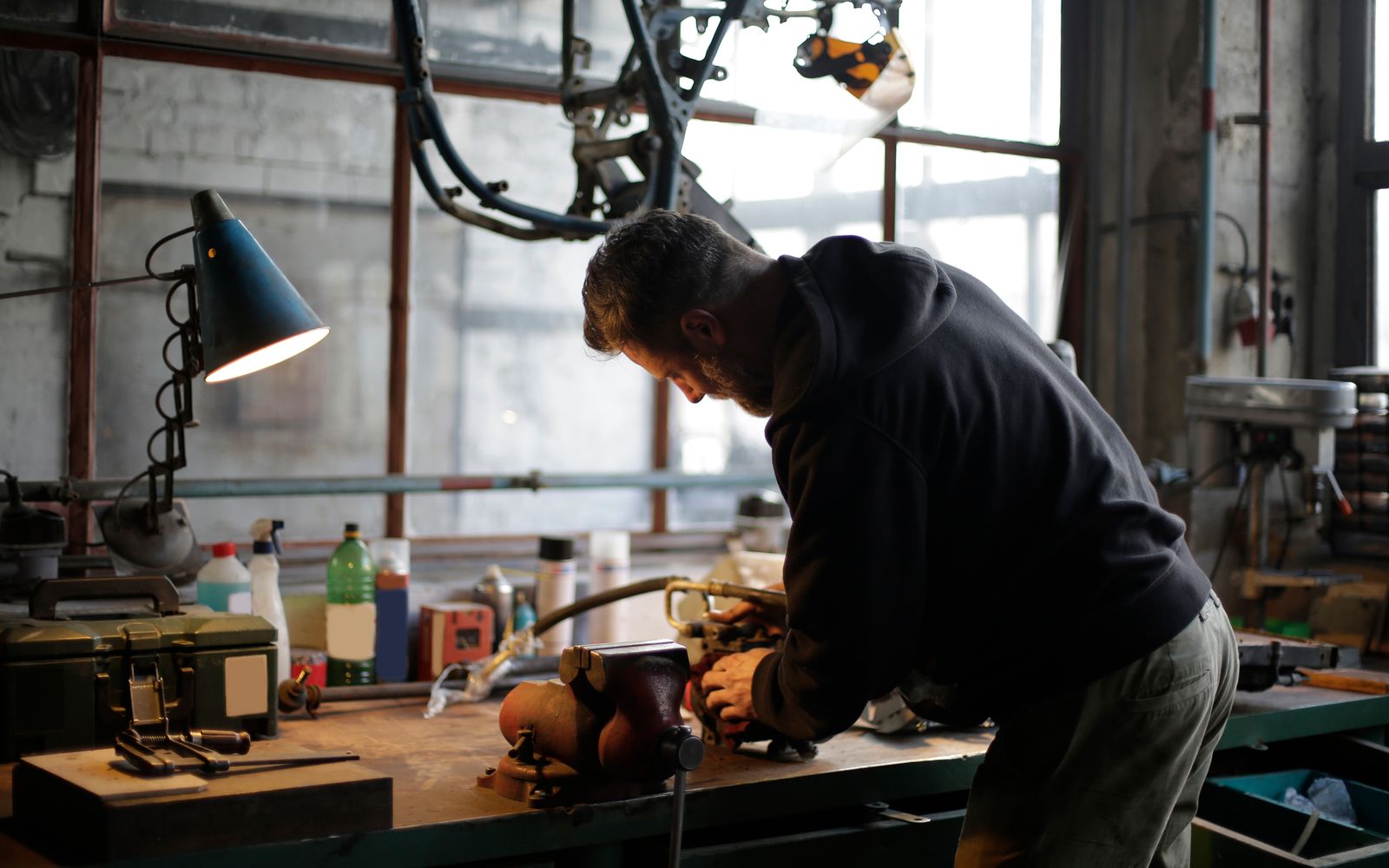 A worker using tools at an industrial workshop workbench